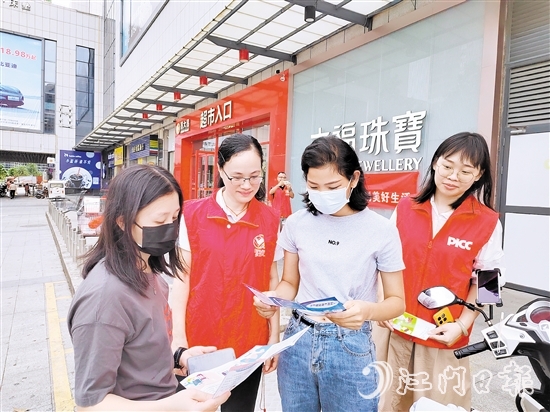 恩平人保財(cái)險(xiǎn)工作人員向群眾派發(fā)宣傳折頁，普及金融知識(shí)。