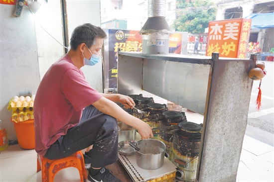 店鋪老板正在烤制爐底糍。