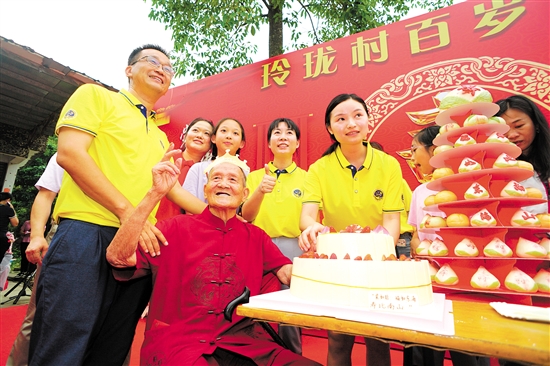 董淑猛（前排左一）、徐娜（豎大拇指者）等人為梁如旺老人慶祝百歲生日。