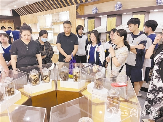 講解員向參觀者們講解標(biāo)本瓶里的珍貴藥材。
