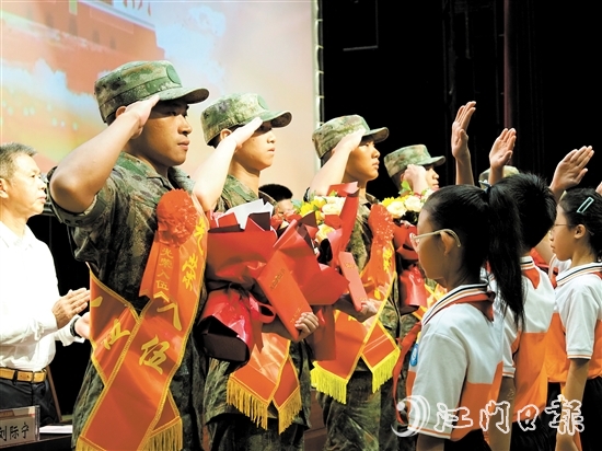 小學(xué)生代表向入伍新兵代表獻上鮮花。