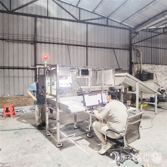 鷹視光電工作人員正在對AI視覺檢測設(shè)備進行調(diào)試。