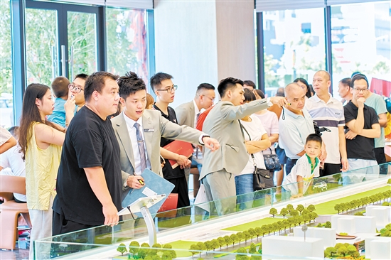 在駿景灣·品悅，銷售人員忙著為客戶介紹樓盤情況。