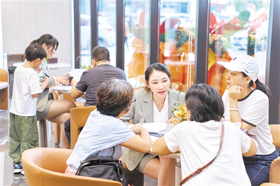 今年國慶假期，全市主要房地產(chǎn)項(xiàng)目認(rèn)購近2300套,圖為銷售人員在接待客人。