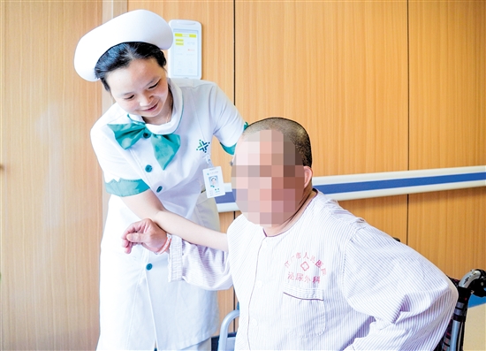 護士攙扶雙下肢無力患者上病床。