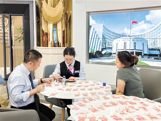 工行江門分行營(yíng)業(yè)部工作人員為客戶鑒別殘幣。