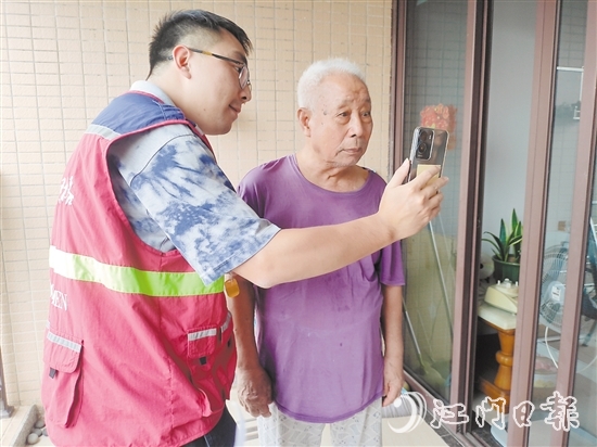 老年人在志愿者幫助下與親人視頻通話。