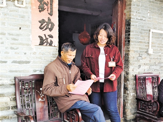 梁鳳琴（右）向群眾派發(fā)宣傳資料。
