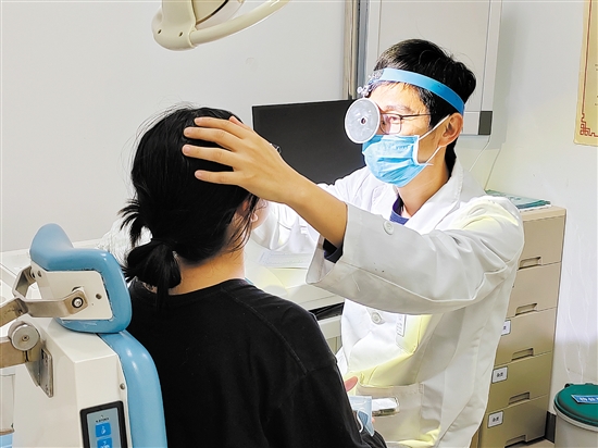 醫(yī)生為患者檢查鼻子。