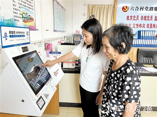 村委會(huì)干部在“粵智助”政務(wù)服務(wù)自助機(jī)上引導(dǎo)村民辦理社保業(yè)務(wù)。