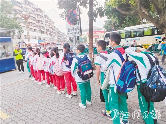 新會(huì)圭峰小學(xué)的學(xué)生有序排隊(duì)，準(zhǔn)備搭乘校園定制公交專線。