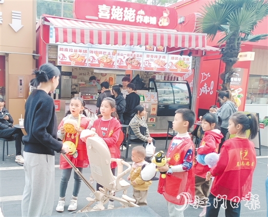 統(tǒng)一身著志愿者服裝的孩子們化身“愛心小掌柜”，向顧客推銷商品。