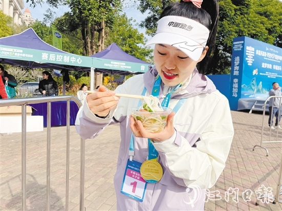恩平溫泉半程馬拉松女子組冠軍郭利亞品嘗恩平瀨粉并點贊。