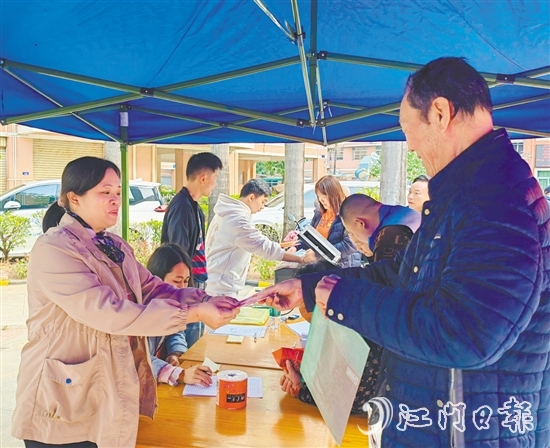 業(yè)委會工作人員向業(yè)主派發(fā)現(xiàn)金福利。