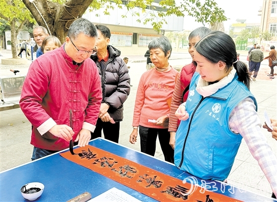 書法家手寫春聯(lián)，為群眾送祝福。