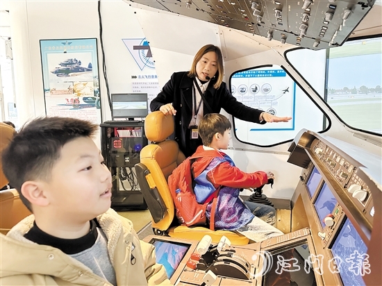 學(xué)生在工作人員的指引下體驗(yàn)中國(guó)商飛C919模擬駕駛。