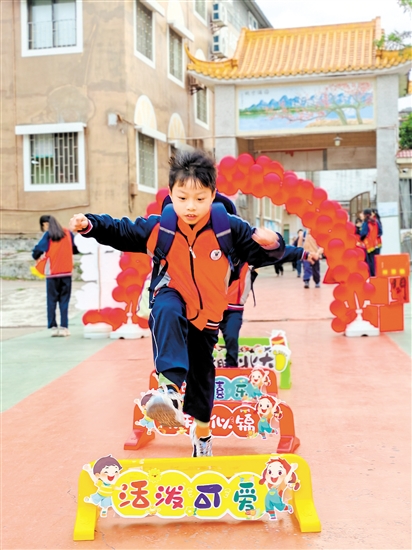 蓬江區(qū)荷塘鎮(zhèn)聯(lián)育小學(xué)學(xué)生跨過吉祥欄。