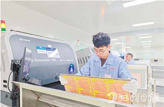 在鶴山中富生產(chǎn)車間，員工操作自動(dòng)化設(shè)備趕制電路板。