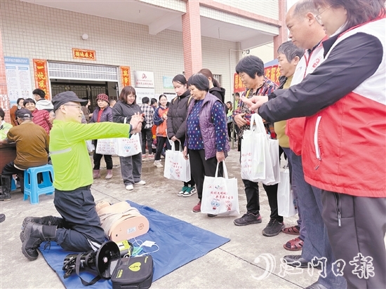 在應(yīng)急安全知識(shí)宣講攤位前，志愿者耐心講解示范急救技能，提升村民的安全意識(shí)和自救互救能力。