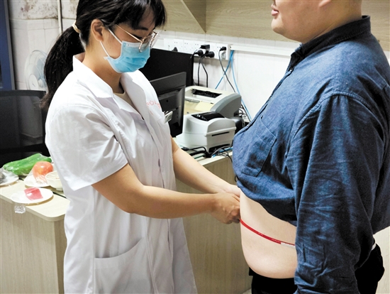 醫(yī)生為記者測(cè)量腰圍。