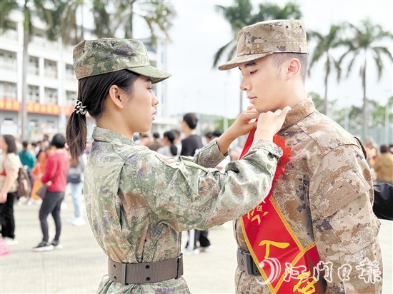 在歡送儀式現(xiàn)場(chǎng)，老兵姐姐為新兵弟弟整理軍裝。