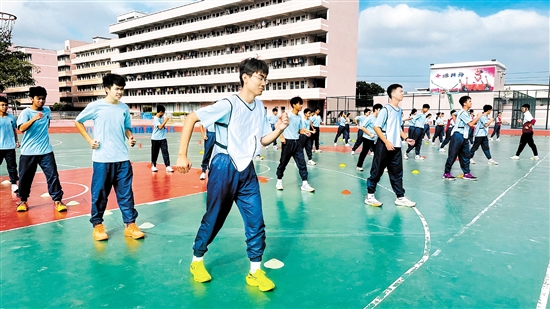 學生們正在進行大課間操前的熱身運動。