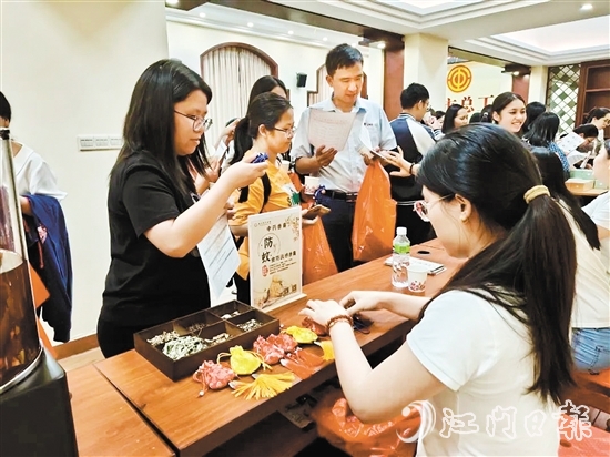 職工們與醫(yī)生探討中藥的成分和比例，制作防感驅(qū)蚊中藥香囊。