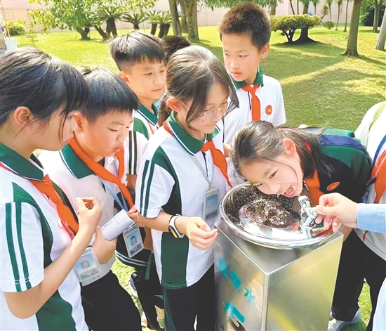 學(xué)生們輪流品嘗經(jīng)過深度處理的直飲水，紛紛點贊“有點甜”。