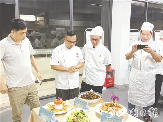 伍立更（左二）對(duì)學(xué)員們的自創(chuàng)菜式一一進(jìn)行點(diǎn)評(píng)和指導(dǎo)。