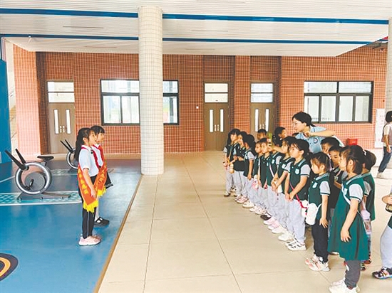 紅領(lǐng)巾講解員帶領(lǐng)孩子參觀校園。