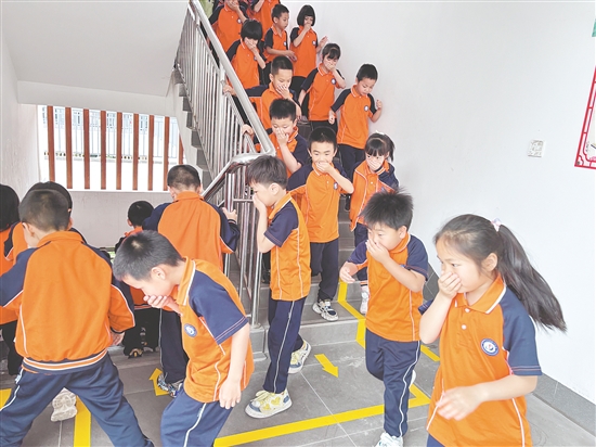學(xué)生們彎腰低頭、捂住口鼻，按照預(yù)定路線有序撤離。