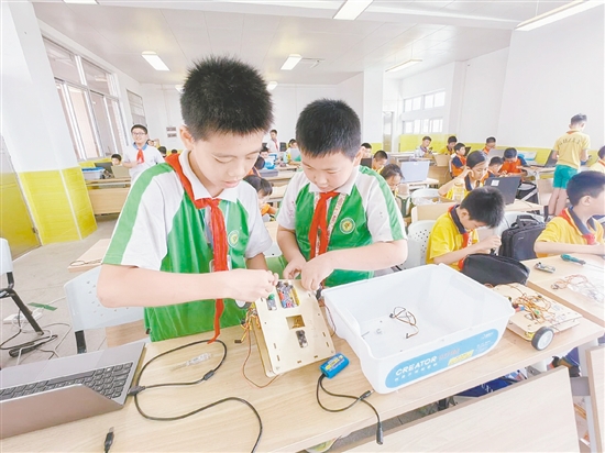 賽場上，小選手們全神貫注地進行機器人編程與調試。