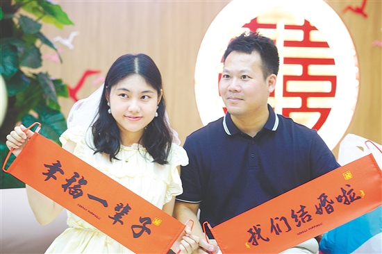 “520”迎來(lái)婚姻登記熱潮，在蓬江區(qū)、江海區(qū)的婚姻登記處，新人拍照留念。江門(mén)日?qǐng)?bào)記者