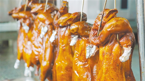 新鮮出爐的燒鵝表皮鮮紅油潤(rùn)，讓人食指大動(dòng)。