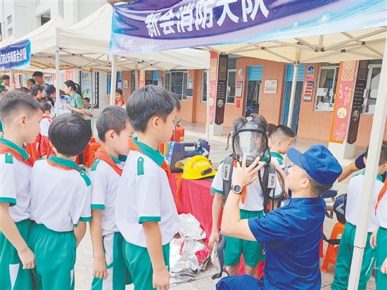 在消防救援大隊(duì)的展示區(qū)，同學(xué)們體驗(yàn)了消防員的空氣呼吸器等裝備。
