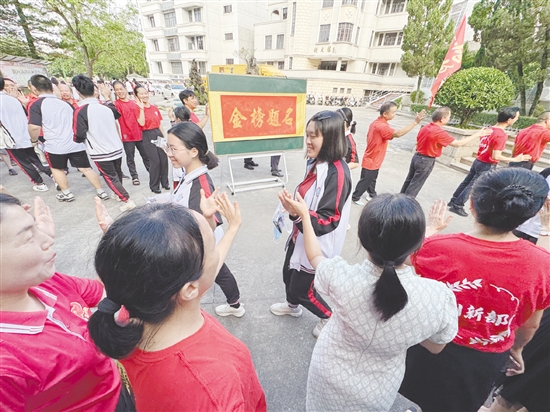 臺山一中在送考路上設置了“金榜題名”大字帖，教師身穿紅衣與學生擊掌，為學生加油。