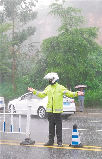 高考期間，交警在大雨中維持交通秩序。