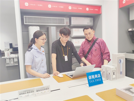 稅務(wù)部門輔導(dǎo)小米之家工作人員為旅客開具退稅申請單。