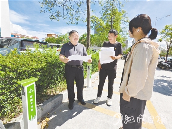 余中宏（左一）與同事一起查看“民生服務(wù)充電站”項(xiàng)目建設(shè)進(jìn)度。