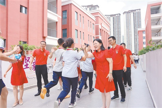 蓬江區(qū)紫茶中學(xué)的領(lǐng)導(dǎo)和老師們與考生們擊掌，為他們加油、鼓勁。
