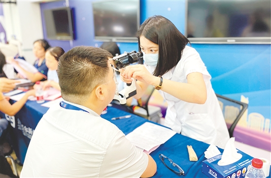醫(yī)護(hù)人員為企業(yè)職工檢查眼睛。