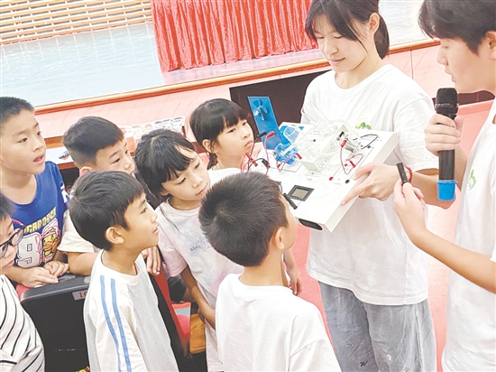 服務(wù)隊隊員向孩子們展示氫燃料電池演示儀。